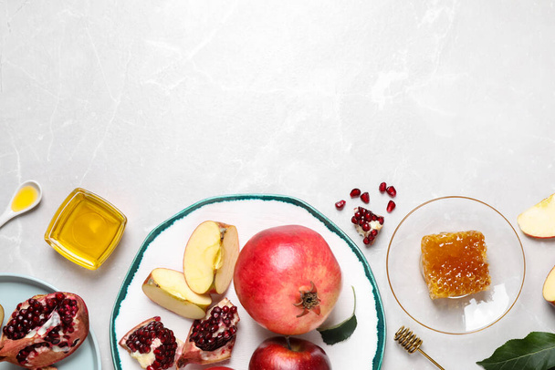 Honey, apples and pomegranates on white table, flat lay with space for text. Rosh Hashanah holiday - Fotografie, Obrázek