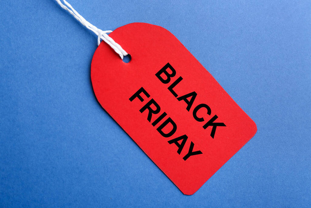 Red blank tag on blue background, top view. Black Friday concept - Фото, изображение