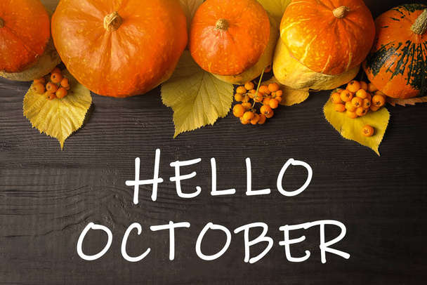 Hello October text, pumpkins on dark wooden background, flat lay - Foto, Bild