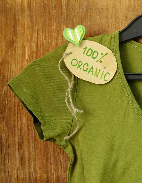 Зеленая рубашка с органической этикеткой на вешалке
 - Фото, изображение