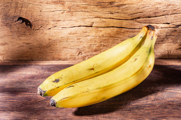 Two bananas on wooden background, close-up image - Photo, Image