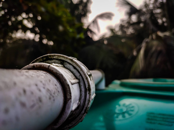 Las juntas de dos tuberías para llenar el agua en el tanque de primer plano en una foto de invierno por la mañana. - Foto, imagen
