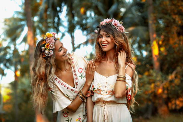 two beautiful young woman in summer dresses outdoors at sunset - 写真・画像