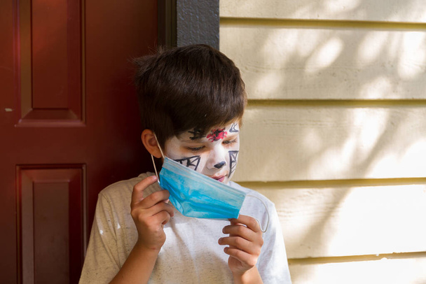 Хлопчик з макіяжем на Хеллоуїн в хірургічній масці
 - Фото, зображення