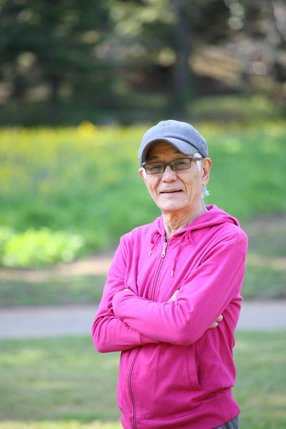  senior Japanese man in pink wear smiles outdoor - Photo, Image