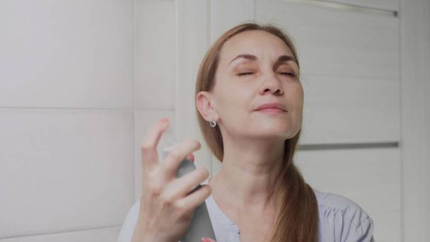 Крупним планом Доросла жінка наносить водяний спрей для зволоження шкіри
 - Фото, зображення