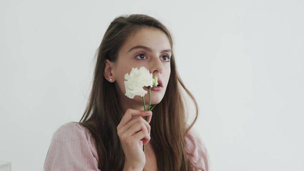 attrayant belle jeune femme modèle avec des fleurs regardant et posant à la caméra - Photo, image