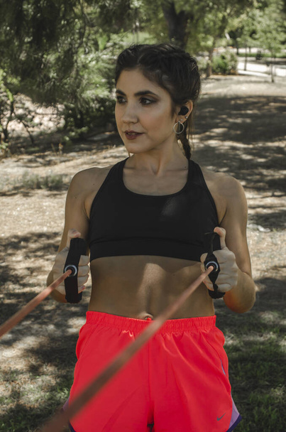 A vertical shot of a Hispanic young female working out outdoors - Foto, imagen