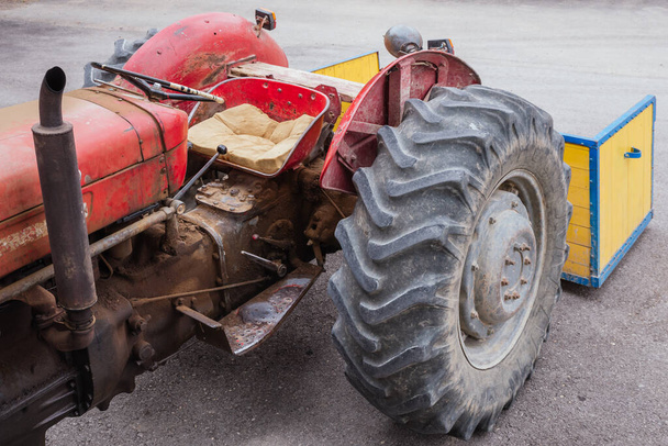 An old vintage red tractor parked at the garden - Fotografie, Obrázek