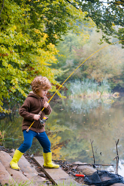 Little boy fishing. Kid pulling rod while fishing on weekend. - Zdjęcie, obraz
