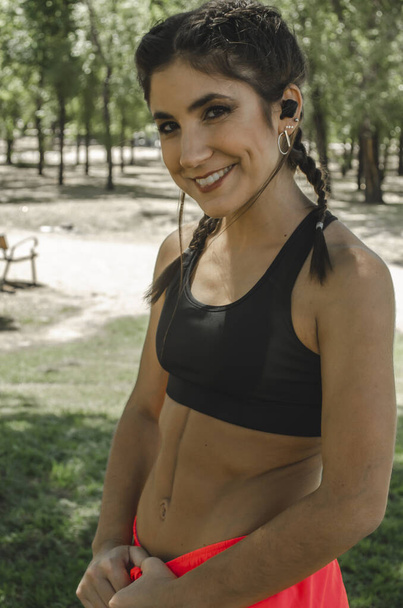 A vertical shot of a Hispanic young female working out outdoors - Photo, image