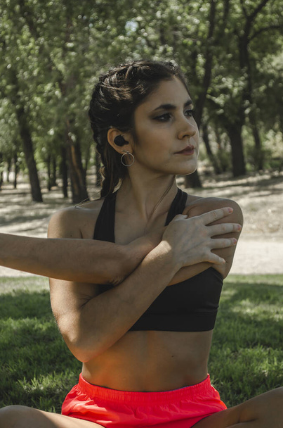 A vertical shot of a Hispanic young female working out outdoors - Foto, Imagen