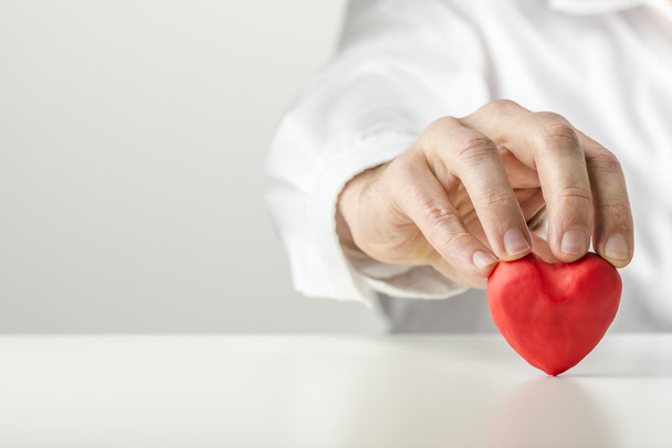 Man holding a Valentine symbolic red heart - 写真・画像