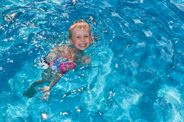 мальчик плавает в бассейне - Фото, изображение