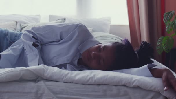 Όμορφη νεαρή Αφρο-Αμερικανίδα που ξυπνάει στο κρεβάτι και κοιτάζει την κάμερα - Πλάνα, βίντεο