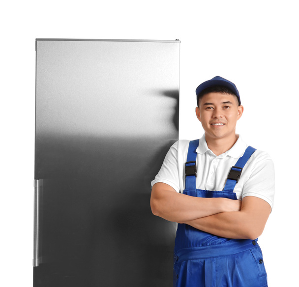 Работник ремонтной службы возле холодильника на белом фоне - Фото, изображение