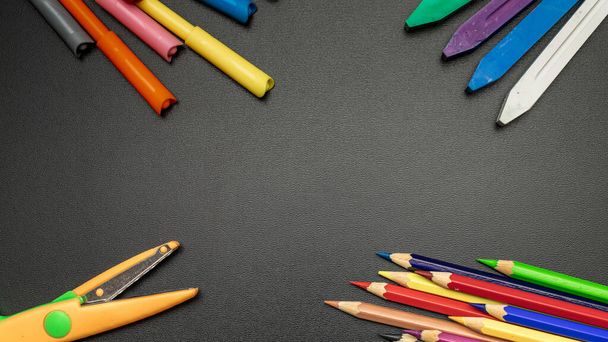Blackboard school. Education accessories with colorful pencils, chalk, brushes on dark school blackboard. Design Copy Space Supplies. Top View, Flat Lay - Foto, Bild