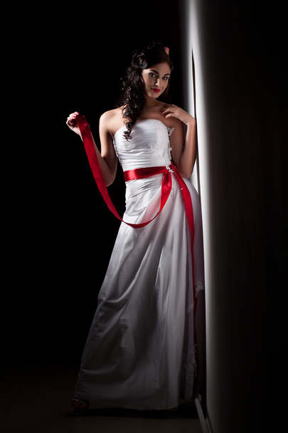 Bride in a white dress with a red ribbon - Photo, image