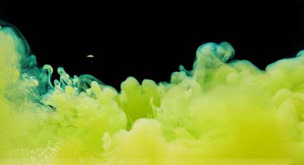 Pintura abstracta colorida La textura del fondo de la pintura acrílica en el agua crea una abstracción interesante sobre un fondo negro. Spray de colores amarillos. - Foto, imagen