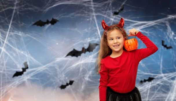 girl in halloween costume with jack-o-lantern - Fotó, kép