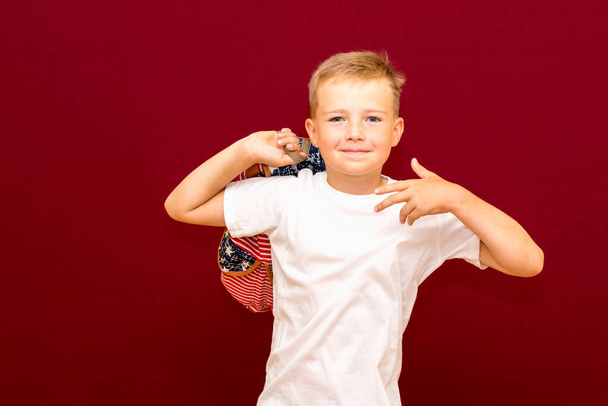 School boy with backpack, isolated on red wall - Photo, Image