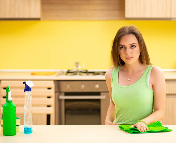 Fiatal Beatifull nő polírozó asztal a konyhában - Fotó, kép