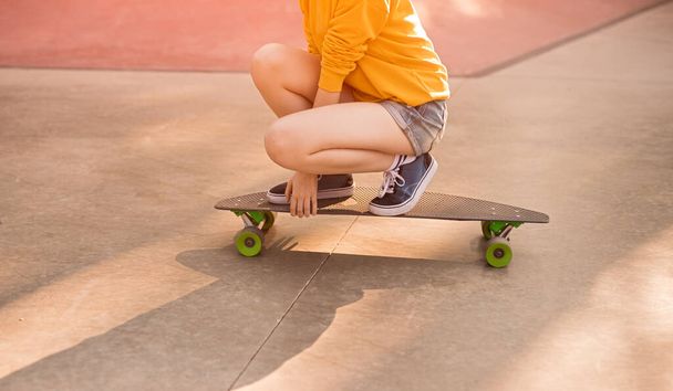 Crop hipster riding skateboard in park - Foto, Imagen
