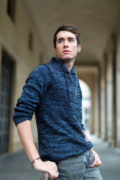 beautiful guy poses in the city center with jacket and dark shirt. High quality photo - Foto, Bild
