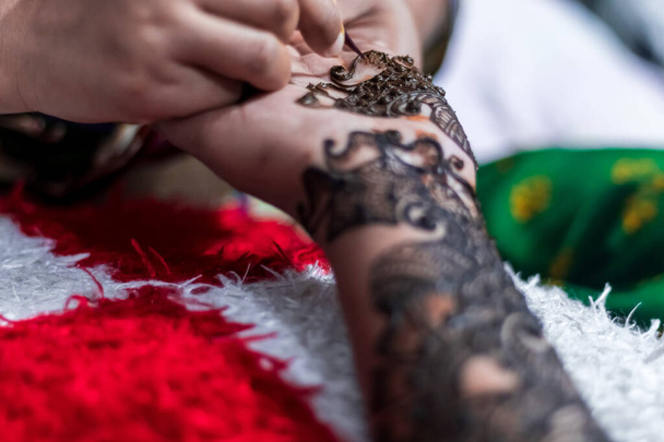 Lähikuva nainen suunnittelee Henna tai Mehendi Tatto kämmenelle tyttö - Valokuva, kuva
