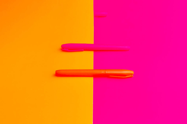 Red orange highlighters at magenta orange background with copy space banner advertisement - Foto, afbeelding