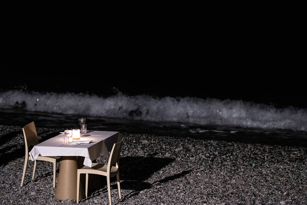 столик на романтический ужин на пляже у моря - Фото, изображение