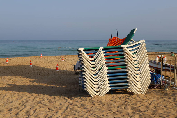 židle stojí na městské pláži na pobřeží Středozemního moře v severním Izraeli  - Fotografie, Obrázek