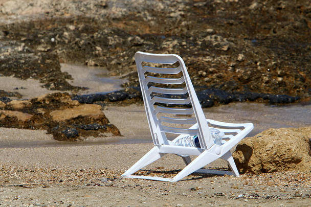 uma cadeira fica em uma praia da cidade na costa mediterrânea no norte de Israel  - Foto, Imagem