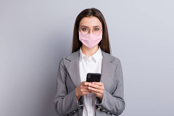 Close-up portrait of her she attractive businesslady wearing safety pink reusable mask using device gadget mers cov influenza remote distance discuss chatting isolated grey color background - Fotó, kép