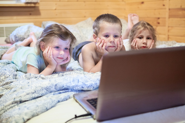 Three children looking at laptop - Фото, изображение