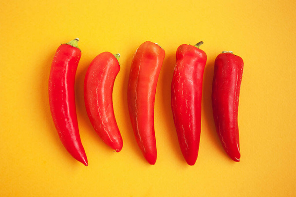 Set of five red peppers on the yellow background - Foto, Imagem
