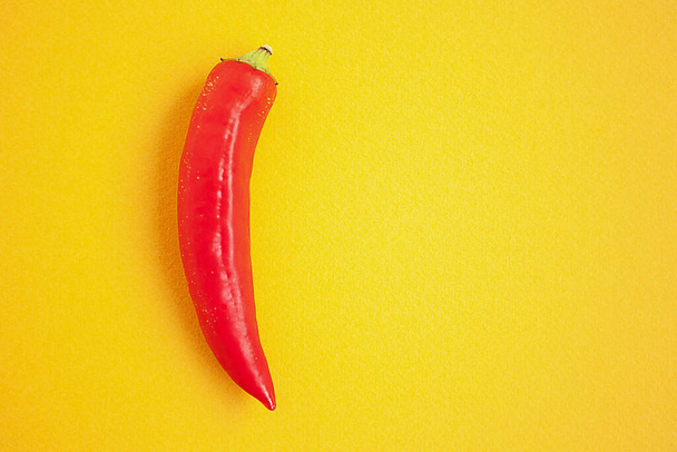 One red pepper on the yellow background - Zdjęcie, obraz