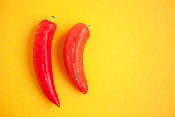 Set of red peppers on yellow background - 写真・画像