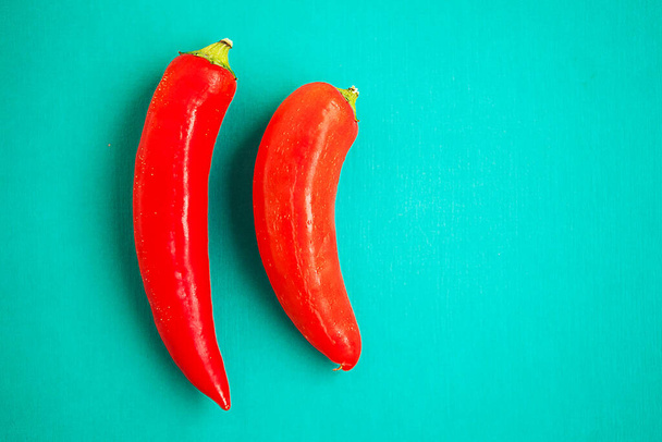 Set of two red peppers on the turquois background - Fotoğraf, Görsel