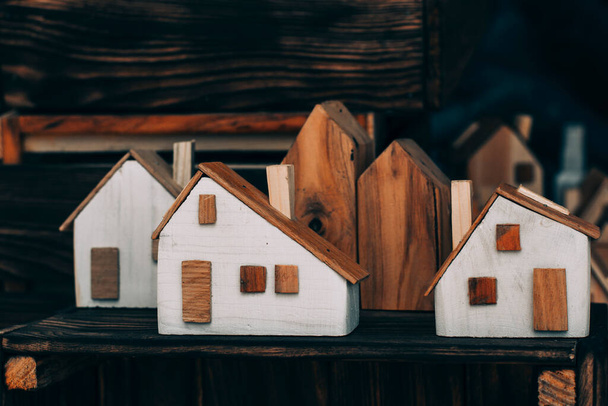 klein speelgoed houten huizen van witte kleur op een plank te koop - Foto, afbeelding