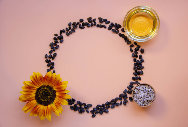 Creative layout of sunflower flowers, sunflower oil, seeds. Minimalism. Healthy food concept. Top view, flat lay, copy space. - Foto, Imagem