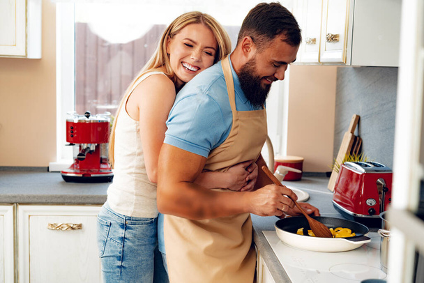 Couple in love preparing meal together in kitchen - 写真・画像