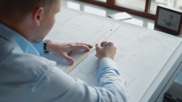 Fiatal mérnök rajz építési terv az irodában - Felvétel, videó