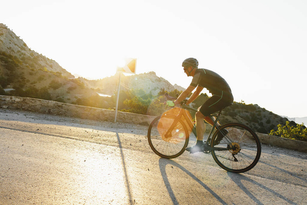Cycling sport athlete man riding on coastal road - Fotoğraf, Görsel