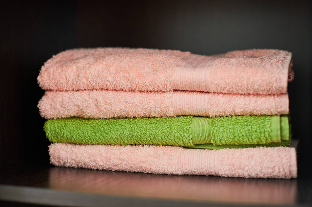 Una pila de toallas. Toallas de baño secas en el armario del gimnasio, de cerca. Toallas suaves y suaves al tacto - Foto, imagen