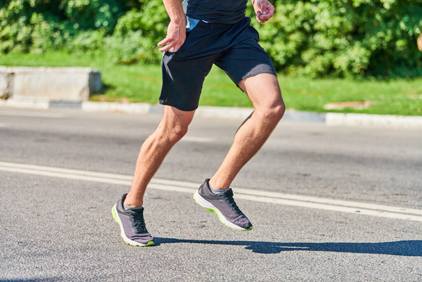 L'homme qui court. Homme athlétique jogging en vêtements de sport sur la route de la ville. Mode de vie sain, passe-temps sportif fitness. Entraînement de rue, sprint extérieur - Photo, image