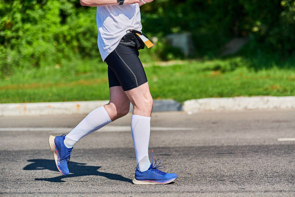 Біжить чоловік. Спортсмен біжить у спортивному одязі на міській дорозі. Здоровий спосіб життя, спортивне хобі. Вуличні тренування, спринтер на відкритому повітрі
 - Фото, зображення