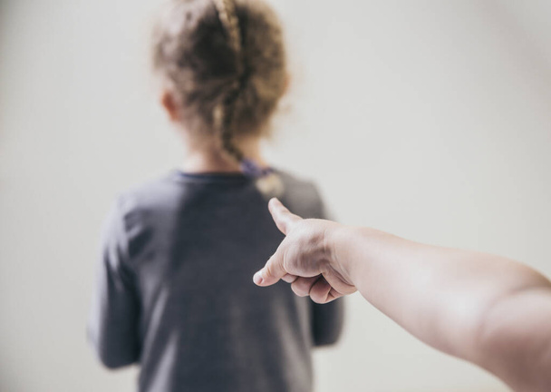 Child bully pointing finger at blurred unrecognizable victim and talking behind back. Bullying concept. - Fotoğraf, Görsel