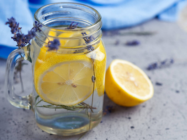Levendula víz citrommal egy üvegben, kék alapon - Fotó, kép
