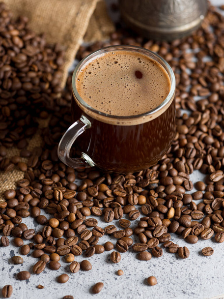 Турецька кава еспресо в скляній чашці на столі з кавовими бобами. - Фото, зображення